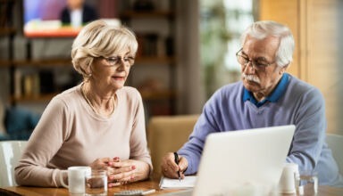 Mature couple using computer while planning their home budget.